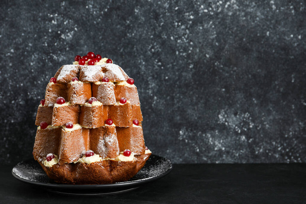 Delicious Pandoro Christmas tree cake with powdered sugar and berries on black table. Space for text - 写真・画像