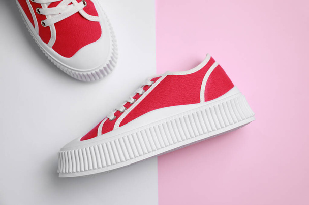 Pair of red classic old school sneakers on color background, flat lay - 写真・画像