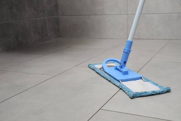 Cleaning grey tiled floor with mop, space for text - Фото, зображення