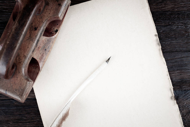Vintage fountain pen and empty sheet of paper on wooden table background - 写真・画像
