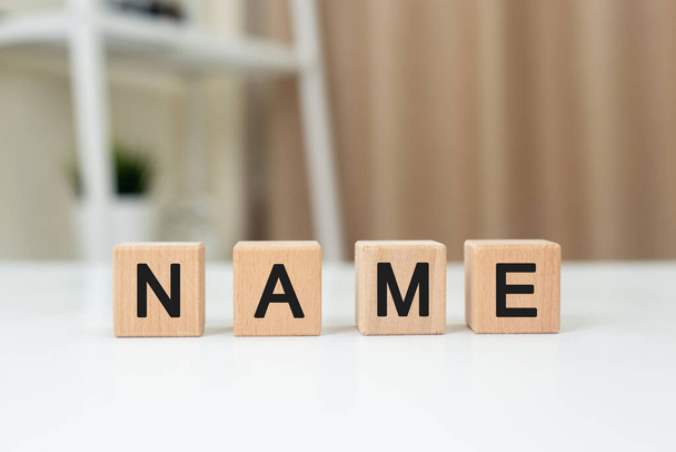 Word NAME on wooden cube block. Alphabet message NAME on table office. Letters in black. Branding text management. Tag label marketing. - Fotoğraf, Görsel