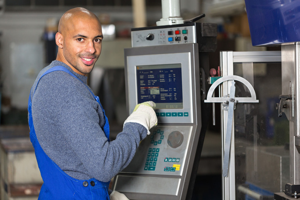 Worker operating a machine with control panel - Φωτογραφία, εικόνα