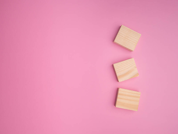 The top view of blank wooden blocks laid an isolated pink background. Space for text. Flat lay. Object concept. - Φωτογραφία, εικόνα