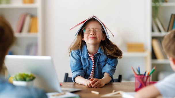 Back to school. Happy child is sitting at desk. Girl doing homework or online education. - Zdjęcie, obraz