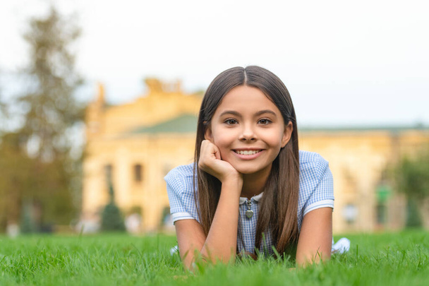 positive girl relax at summer lawn with grass. girl relax at summer lawn outdoor. photo of girl relax at summer lawn. girl relax at summer lawn. - Φωτογραφία, εικόνα