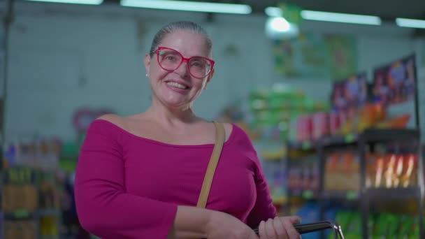スーパーマーケットでバスケットを保持する喜びの女性,幸せな買い物客のライフスタイルの肖像画 - 映像、動画