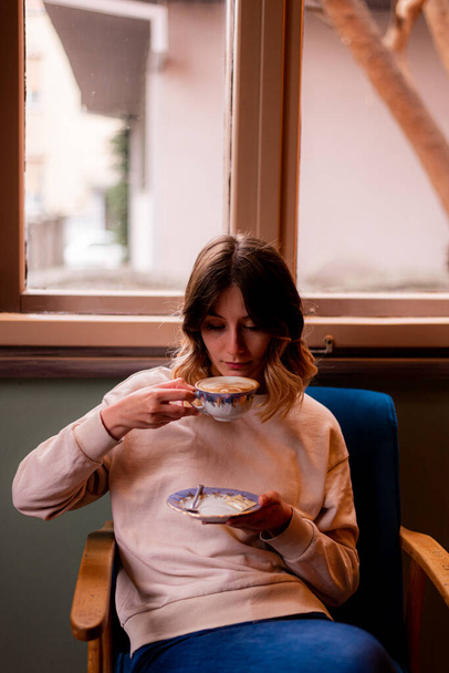 Dívka na kávu, zatímco sedí v kavárně - Fotografie, Obrázek
