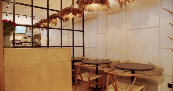 Moderní minimalistická kavárna s dřevěnou židlí a stolem. Prázdná jídelní látka a dřevěná židle. Moderní restaurace kavárna v dřevěném interiéru. dřevěné čáry,  - Záběry, video