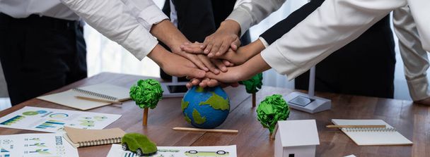Bir grup iş adamı, Dünya 'yı kurtarmak için şirket işbirliğinin sinerjisini gösteren el yığınları koydular. Çevresel farkındalık ve ekolojik birlik kavramı. Önde. - Fotoğraf, Görsel