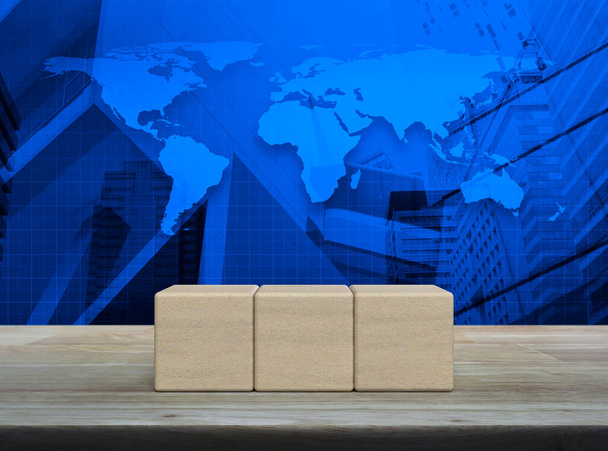 Three block cubes on wooden table over world map, modern office city tower and skyscraper, Elements of this image furnished by NASA - Fotografie, Obrázek