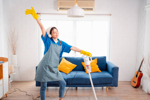 Happy Housework or house keeping service female singing and cleaning dust in house, cleaning agency small business. professional equipment cleaning old home. - Φωτογραφία, εικόνα