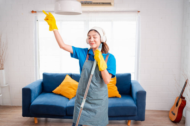 Happy Housework or house keeping service female singing and cleaning dust in house, cleaning agency small business. professional equipment cleaning old home. - Zdjęcie, obraz
