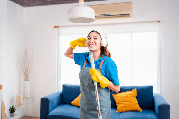 Happy Housework or house keeping service female singing and cleaning dust in house, cleaning agency small business. professional equipment cleaning old home. - Foto, imagen
