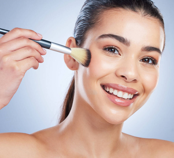 Beauty, cosmetic and portrait of woman with a makeup brush in studio for glamour facial routine. Self care, happy and young female model from Brazil with cosmetology face isolated by gray background - Φωτογραφία, εικόνα