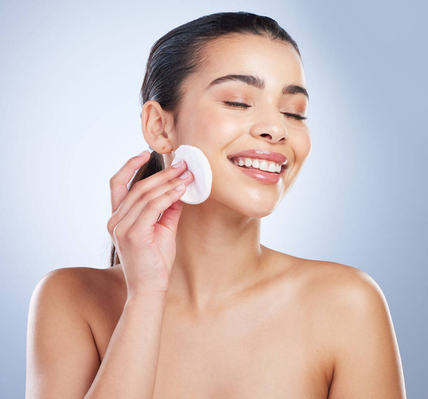 Skincare, pad and asian woman in studio for makeup removal, toner or hydration on grey background. Smile, beauty and asian lady wellness model with facial cotton for cleaning or glowing skin routine. - Φωτογραφία, εικόνα