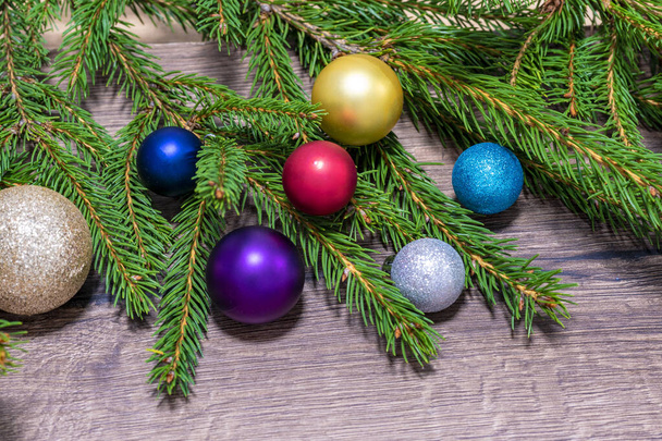 クリスマスの木製の背景。モミの枝と赤、黄色の果実のクリスマスの装飾。木の机を閉じて、茶色のボード。コピースペース - 写真・画像