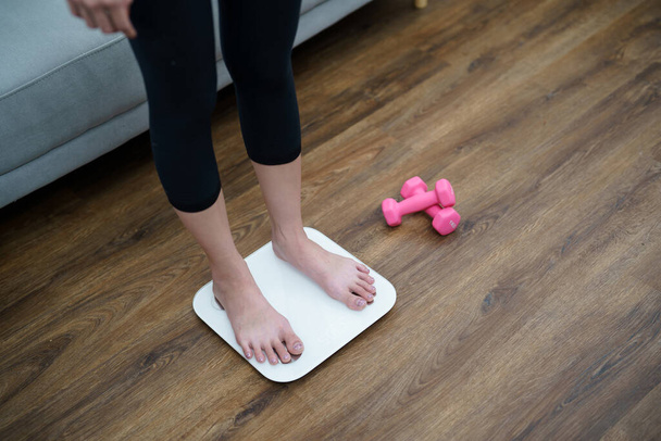 Diät und Waagenfüße stehen auf elektronischen Waagen zur Gewichtskontrolle. Messgerät in Kilogramm für eine Diätkontrolle. - Foto, Bild