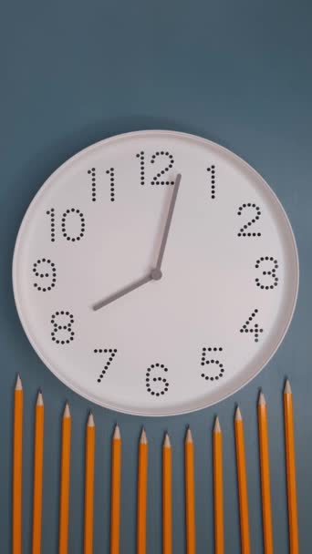 Clock is running fast. Watch with white clock face on blue table background with pencils. Hyperlapse. Concept of study, deadline, schedule. - Footage, Video