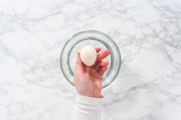 Mermer mutfak tezgahında haşlanmış yumurta soymak.. - Fotoğraf, Görsel
