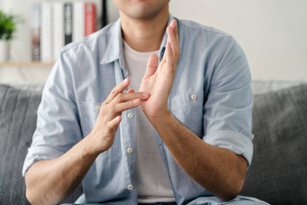 Щасливий молодий глухий чоловік, який послуговується мовою жестів, щоб спілкуватися з іншими. - Фото, зображення
