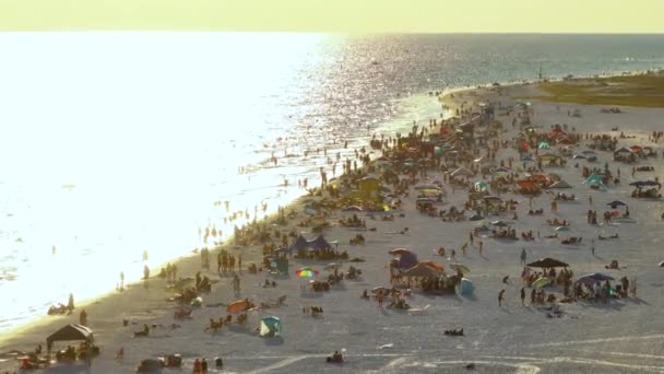Näkymä ylhäältä illalla Siesta Key beach valkoinen hiekka täynnä turisteja Sarasota, USA. Monet ihmiset nauttivat loma-ajasta uinti Meksikonlahdella vesi ja rentouttava lämmin Florida aurinko. - Materiaali, video