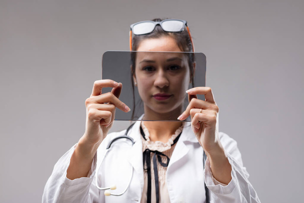 Lékařka analyzuje Vaše údaje o COPYSPACE na digitální tabletě. Futuristická průhledná obrazovka je pro váš vstup prázdná. Brýle nosí jako čelenku, myslí to vážně. - Fotografie, Obrázek