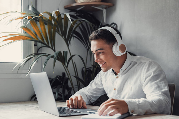 Homem de negócios feliz usando fones de ouvido e usando laptop, curtindo faixa, ouvindo música - Foto, Imagem
