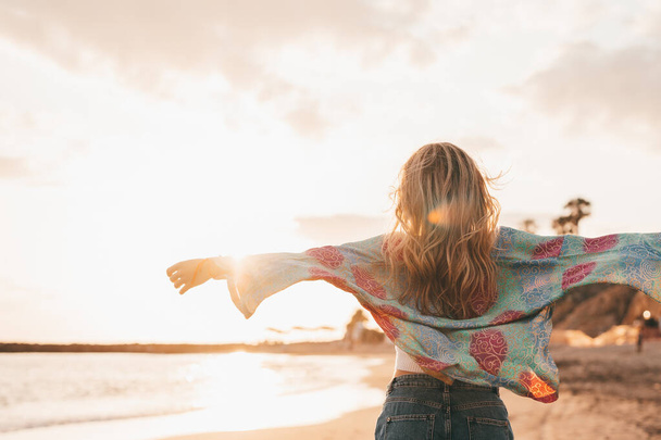 zpět pohled blondýny žena chůze na pláži a těší západ slunce  - Fotografie, Obrázek
