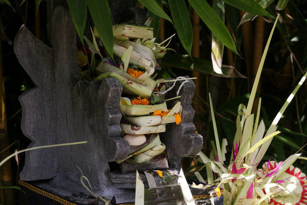 Κανάνγκ σάρι, υφασμένο δοχείο μπαμπού με ρύζι, λουλούδια, θυμίαμα, γλυκά και φρούτα. Αυτή είναι μια προσφορά στους Θεούς, ως χειρονομία ευγνωμοσύνης στο Μπαλί της Ινδονησίας.. - Φωτογραφία, εικόνα