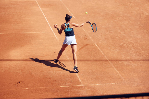 Top view image of young woman, tennis player in motion during game at open air tennis court. Training session. Concept of sport, hobby, active lifestyle, health, endurance and strength, ad - Fotó, kép