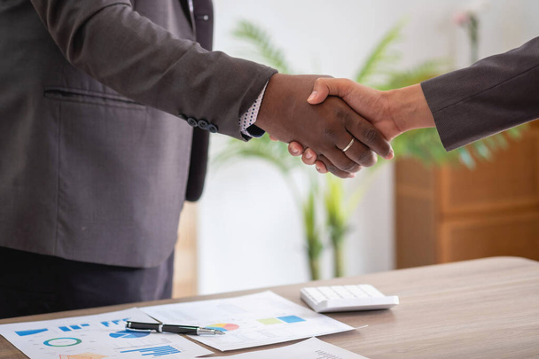 Satisfied black client shaking hands, thanking the manager for good financial deal African American businessmen shaking hands after successful business negotiations. Hiring. Buying services. - Photo, Image