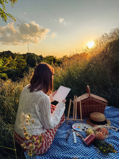 Ressamların cenneti: kadın piknik sırasında sanat yarattı. - Fotoğraf, Görsel