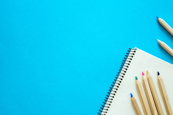 青い背景、学習、研究、プレゼンテーションの概念上の色鉛筆とSketchbook. - 写真・画像