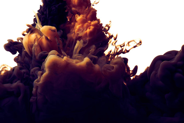 Splash van oranje en zwarte verf in water over witte achtergrond - Foto, afbeelding