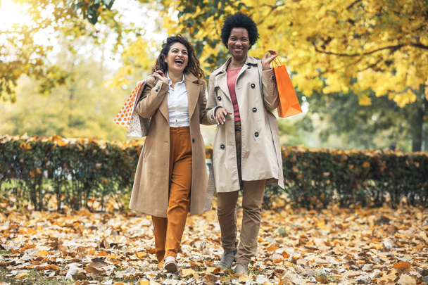 Šťastná žena přátelé procházky v lese na podzim s nákupními taškami. - Fotografie, Obrázek
