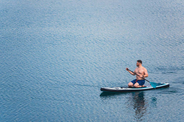 Gölün ortasındaki kürekli adam fotokopi alanının ortasında. - Fotoğraf, Görsel