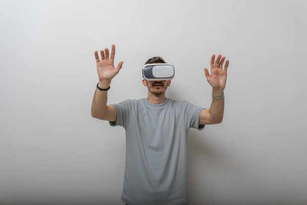 仮想現実の眼鏡をかけた未来の男は、孤立した灰色の背景の中で空気と相互作用する。高品質の写真 - 写真・画像