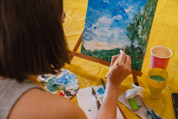 Femme avec peinture au pinceau sur toile salle de classe - Photo, image