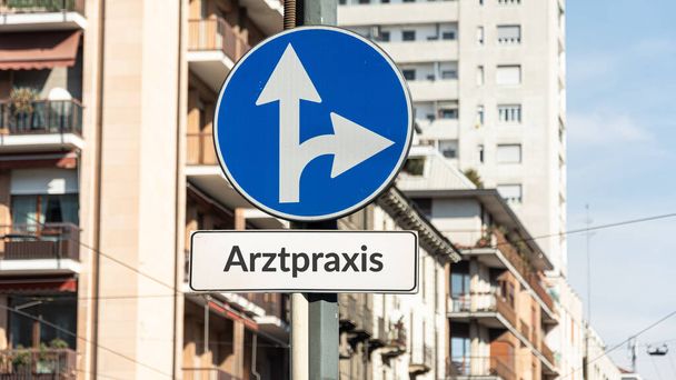 Image shows a signpost and a sign in the direction of a doctor's office in German. - Photo, Image