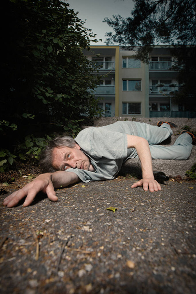 Addicted old man drunked in summer city park inable to walk - 写真・画像