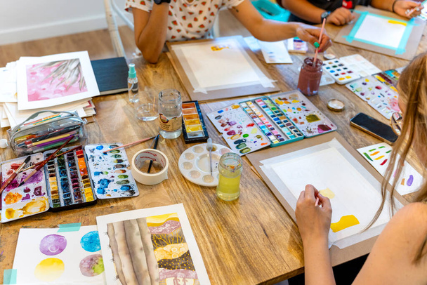 Oficina de aquarela. Sinfonia de aquarela: Mulheres harmonizando cores e pinceladas na oficina - Foto, Imagem