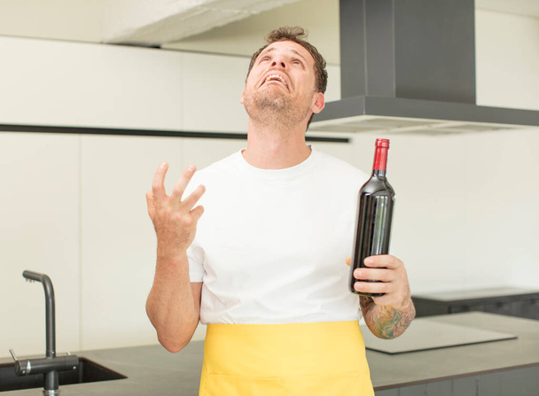 screaming with hands up in the air. bottle of wine concept - 写真・画像