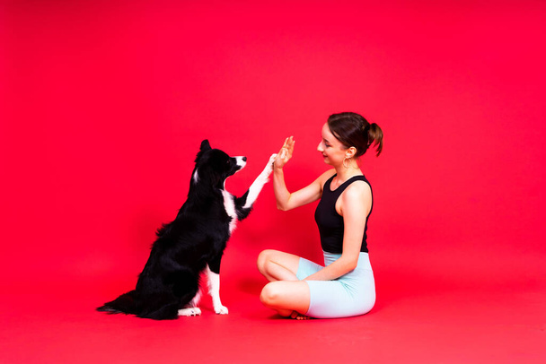 Woman walks and getting exercise for both herself and her border collie dog. - 写真・画像