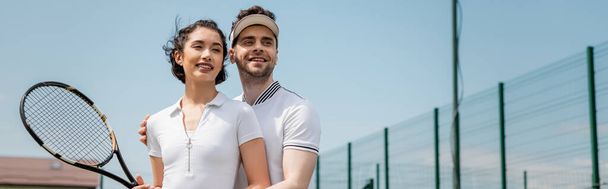 banner, romance on tennis court, happy man teaching girlfriend how to play tennis, summer sport - Foto, imagen
