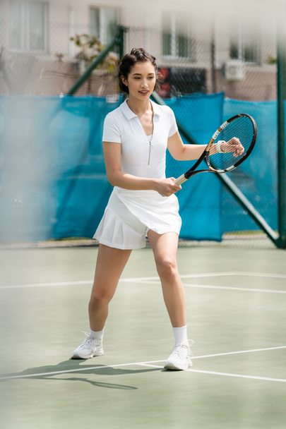 joueuse heureuse en robe sportive tenant la raquette sur le court de tennis, sport d'été, passe-temps et santé - Photo, image