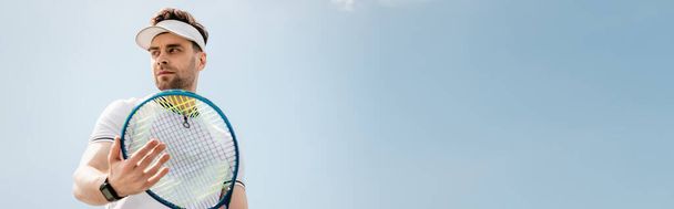 bannière, bel homme en tenue active et bonnet de visière tenant raquette de tennis sur le court, le sport et les loisirs - Photo, image