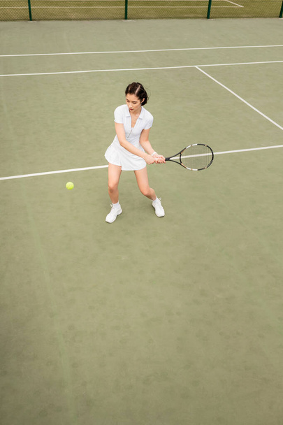 revés, vista aérea de una jugadora en activo jugando tenis, raqueta y pelota, hobby - Foto, Imagen
