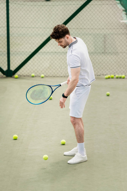 balles de tennis autour du sportif avec raquette sur le terrain, passe-temps et loisirs, beau joueur - Photo, image