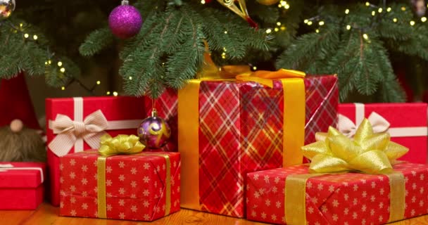 Купка різдвяних подарункових коробок на підлозі під красивою ялинкою. Високоякісні 4k кадри - Кадри, відео