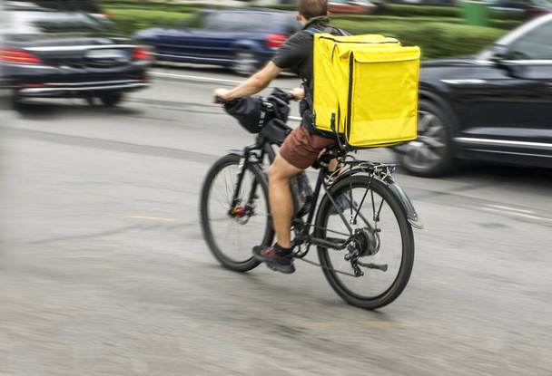 Motion blur, a courier on a bicycle is in a hurry to deliver an order - Foto, immagini